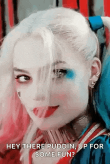 a woman in a harley quinn costume is smiling and looking at the camera while wearing makeup .