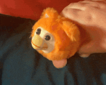 a person is holding an orange stuffed animal that looks like a monkey