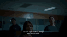 a group of people are sitting in a dark room and a woman is talking to a man .