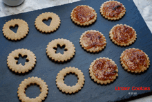 a tray of linzer cookies sits on a black surface