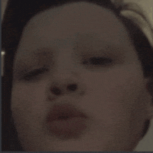 a close up of a child 's face with his eyes closed and his mouth open