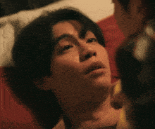 a man is laying on a bed with his eyes closed