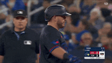 a baseball player is standing in front of a scoreboard that says sn on it