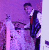 a man in a tuxedo stands in front of a purple light