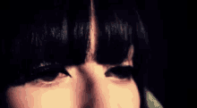 a close up of a woman 's eyes with a fringe .