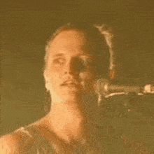 a man is singing into a microphone and making a face .