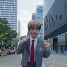 a man in a suit and tie is giving a thumbs up sign