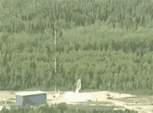 a rocket is flying through the air over a field and landing on the ground .