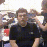 a man in a black shirt is being photographed by two women