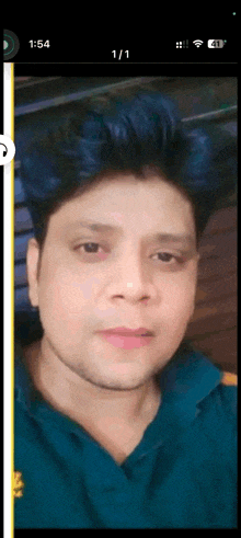 a man 's face is shown on a cell phone screen with the time 1:54