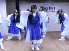 a group of people are dancing in front of a big hit entertainment sign