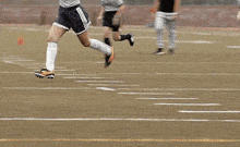 a soccer player is kicking a soccer ball with his foot