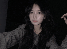 a woman with long black hair is taking a picture of herself