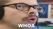 a man with glasses and a mustache has his mouth open and the word whoa is on his face