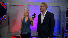a man and a woman are standing next to each other and the man is wearing a suit and the woman is wearing a vest