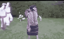 a man in a striped shirt is holding a woman in a skirt