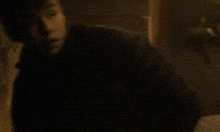 a man in a black jacket is looking down with his head down