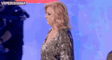 a woman is standing in front of a blue background with the words viperissima on it
