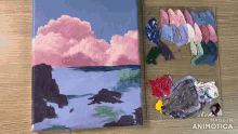 a painting on a canvas next to a palette with the words made in animotica on the bottom