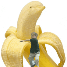 a boy is standing inside of a banana with a dolphin head on it