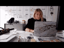 a woman sits at a desk with a laptop and a sign that says startup live