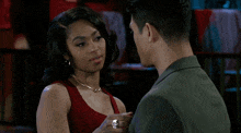 a man and a woman are looking at each other and the woman is wearing a ring