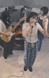 a girl singing in front of a drum set that says 246 on it