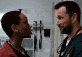 a man and a woman looking at each other with a stethoscope around their necks