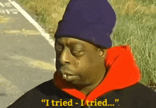a man wearing a purple beanie and an orange hoodie says " i tried - i tried "