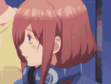 a girl with red hair and blue eyes is wearing headphones and a blue jacket .