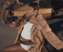 a woman is wearing a fur coat and taking a picture of herself .