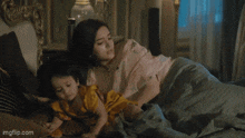 a woman is sitting on a couch holding a child .