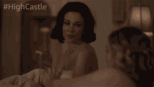 a woman smoking a cigarette next to another woman with #highcastle on the bottom right