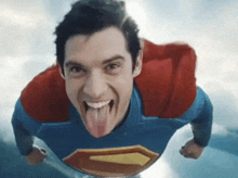 a man in a superman costume sticks his tongue out