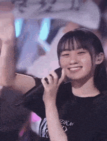 a young girl is smiling while holding a microphone .