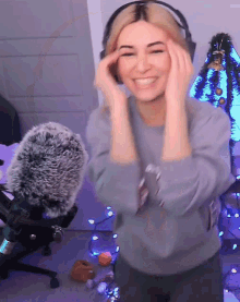 a woman wearing headphones is smiling and dancing