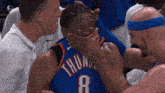 a man in a thunder jersey covering his mouth with his hand