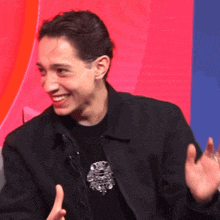a young man wearing a black jacket and a black shirt with a skull on it