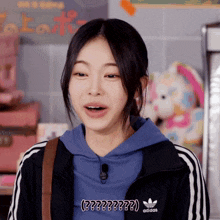 a girl wearing a blue hoodie and black adidas jacket