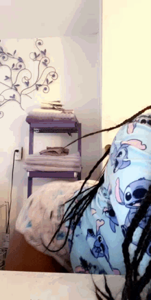 a person wearing a blue stitch pajama is standing in front of a mirror