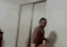 a blurry picture of a man standing in front of a door .