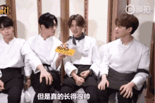 a group of young men sitting next to each other with a sign that says sina on it