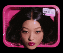 a woman 's head in a pink plastic container with a label that says all natural beef