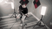 a man is playing a guitar in a room with a lot of lights