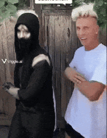 a man in a white shirt is standing next to a man in a black hoodie
