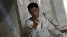 a man in a white and gold suit with a lightning bolt on his chest