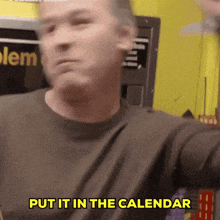 a man says put it in the calendar in front of a yellow wall