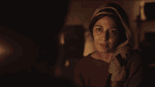 a woman with a scarf around her head is looking at the camera