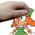 a hand is touching a cartoon character with a green hat on