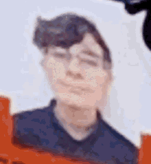 a blurry picture of a young man with glasses and a black shirt